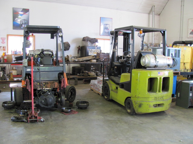 Photo of two forklifts in the process of being repaired